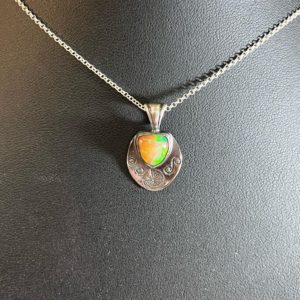 Green and orange pendant on a black display.