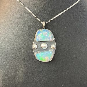 Opal pendant on a black display.